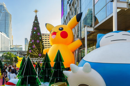 Bangkok, Thailand - Dec 28, 2023: Christmas and New Year decoration design with Pikachu Pokemon theme, Japanese cartoon, with background of large Christmas tree in front of the Central World mall.のeditorial素材