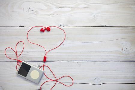 music player with red earphone on white wood backgroundの写真素材