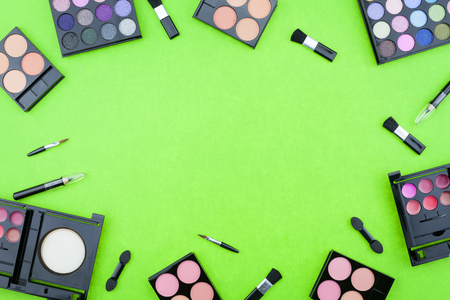 Flat lay photo of various makeup brush, eyeshadow and cosmetics on colorful paper backgroundの写真素材