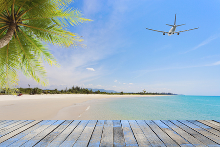 Wood floor with coconut palm trees on tropical island and airplane,concept summer and travel background の写真素材