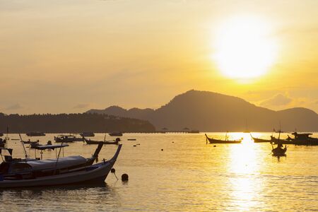 Beautiful sunrise seascape view with boat in phuket islandの写真素材