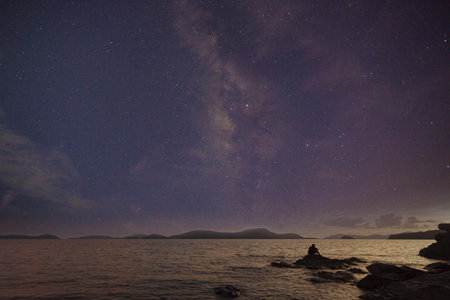 Photographer doing astro photography on the rocks of nightscape with milky way galaxy in thailandの写真素材