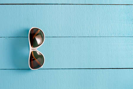 sunglasses on blue wooden background copy space for your text and design or backgroundの写真素材