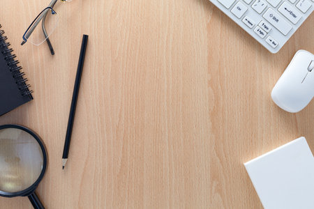 business objects of pencils,white paper note,keyboard,mouse, and glasses on wooden office desk for...