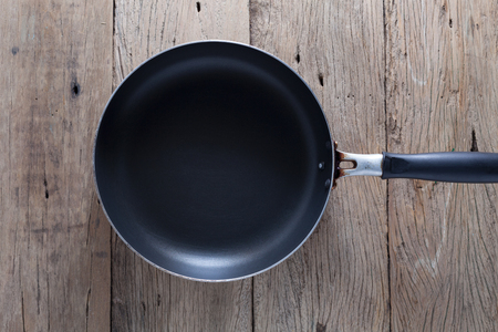 Top view big frying pan on old wooden tableの写真素材