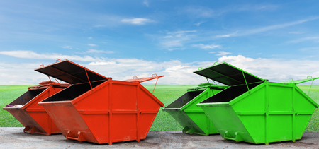 Colorful Industrial Waste Bin (dumpster) for municipal waste or industrial waste on green grass and blue sky background,with ecology conceptの写真素材