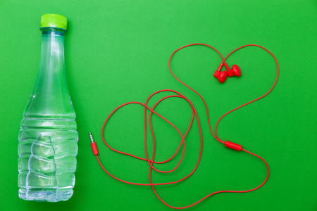 close up of water bottle and earphones on green background,fitness background conceptの写真素材