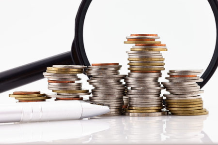 Magnifying glass with pile of coins,concept finance and banking backgroundの写真素材
