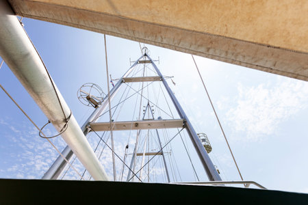 Sailing yacht masts against sky and clouds background