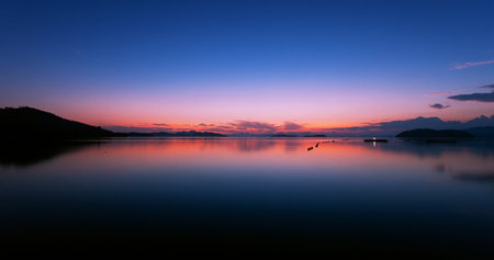Long exposure image of Dramatic color sky seascape with reflection in sunset or sunrise scenery nature for backgroundの写真素材