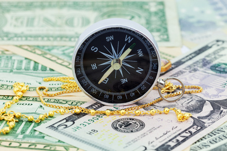 compass and gold necklace on money banknotes Euro and Dollars,concept of business planning and finance and savingsの写真素材