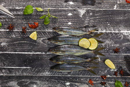 Row of fish on black wooden background,concept cooking background.の写真素材