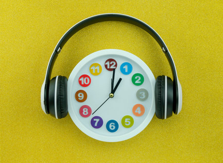 White clock with headphone on beautiful gold color background.