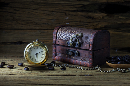 Old pocket watch and Treasure Chest on dark wood, still life.の写真素材