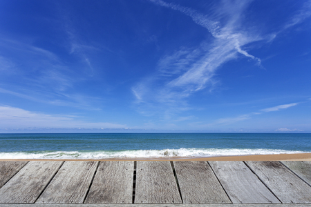 Wooden floor with beautiful blue sky over tropical sandy beach scenery for background.の写真素材