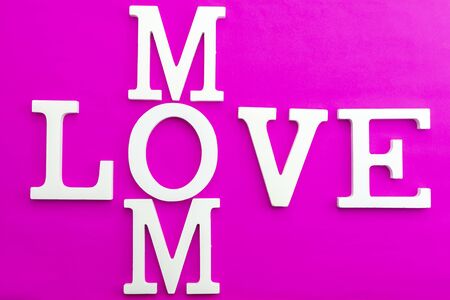 Happy mothers day concept,Love mom wooden text on pink paper background.の写真素材