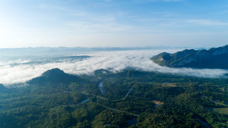 Aerial view drone shot of flowing fog waves on mountain tropical rainforest.