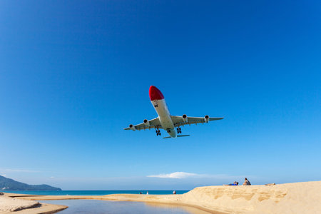 Commercial airplane landing above sea and clear blue sky over beautiful scenery nature background...