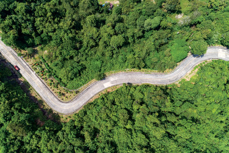 Aerial view drone shot top view of Asphalt road curve on mountain tropical rainforest with mountain...