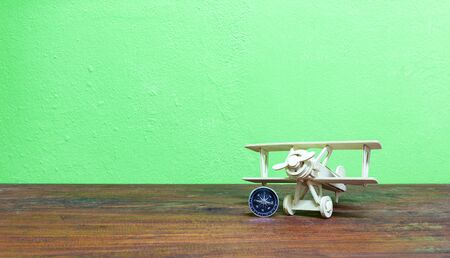 Wood airplane with compass on wooden plank Green background.の写真素材