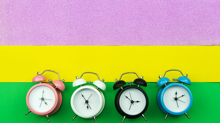 Flat lay retro beautiful new alarm clock on sweet colorful paper pastel color background