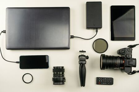 Digital camera with lenses and equipment of the professional photographer on white leather backgroundの写真素材