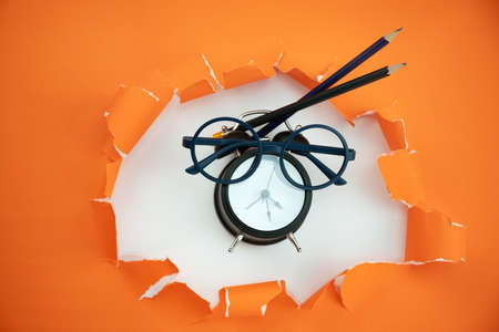 Education objects on orange ripped open paper backgroundの写真素材