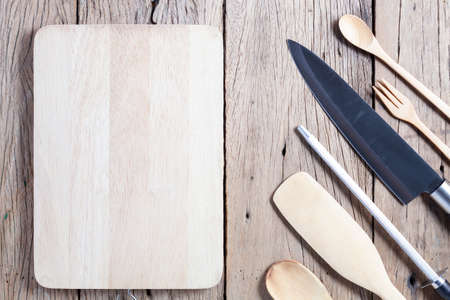 Knife and Sharpener with kitchenware on old wooden table backgroundの写真素材
