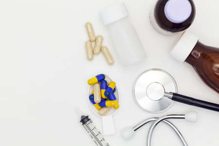 Stethoscope with bottle of medicine,feeding syringe drug and herb capsule on white backgroundの写真素材