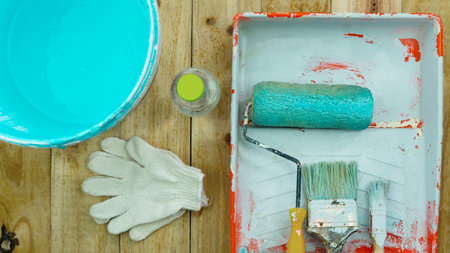 Set of tools for painting wall on wood background at home.