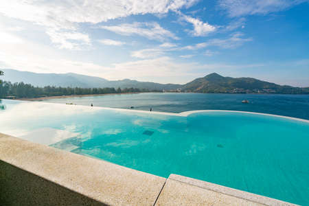 Swimming pool with stair on top of roof deck building looking at view tropical sea ,Luxury beach villa house with sea view swimming pool in modern design,Summer Vacation and travel background concept.の写真素材