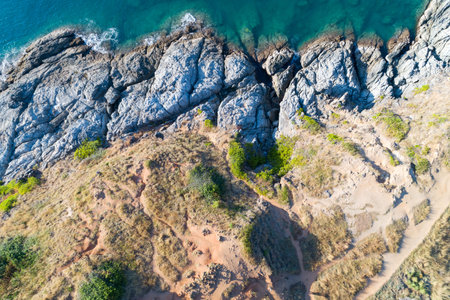High angle view Tropical sea with wave crashing on seashore and high mountain located in Phuket...