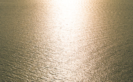 Aerial view Texture of Golden sea surface with small waves in the sea and Beautiful light sunset or sunrise over sea surface dark Golden sea texture background.の写真素材