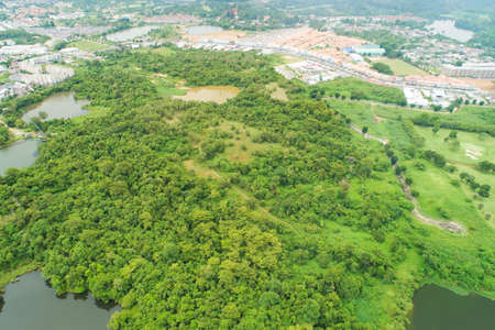 Aerial view drone Top down shot of abundant forest with the city surrounds forest in summer time High angle view Nature environment Conceptの写真素材