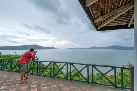 Professional man setting Mirrorless Camera taking picture Landscape nature view at Kaokad view point Phuket Thailand Landmark famous tourist destination to see Sunset and tropical seashore at Phuketの写真素材