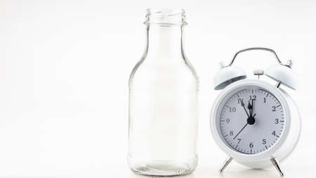 Banner of a glass of milk with white alarm clock on colorful background Copy spaceの写真素材