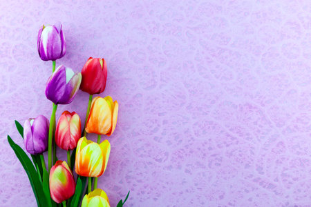 A bouquet of colorful tulips on purple paper background Spring flower arrangement Background.