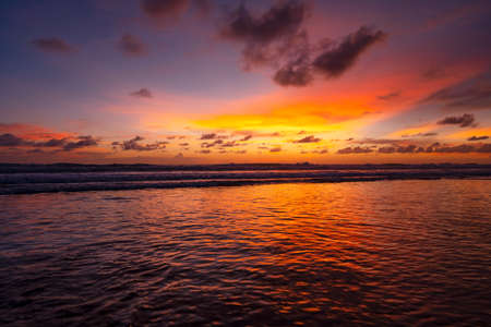 Colorful sky sunset or sunrise Burning colourful sky and shining waves crashing on sandy shore Beautiful light reflection on sea surface Amazing landscape or seascape nature twilight background.の写真素材