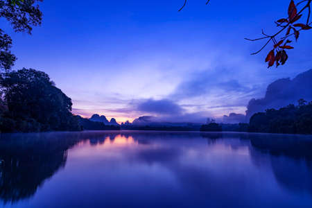 Beautiful landscape nature view sunrise morning with reflections light over water surface during sunrise scenery mountain background.の写真素材