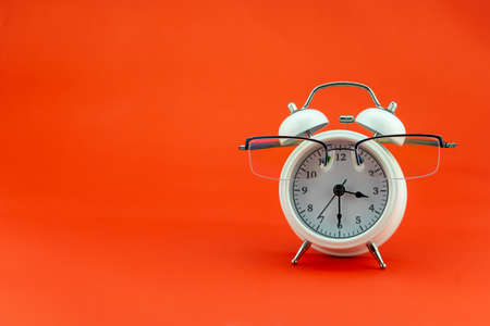 Concept Education or business Alarm clock and teacher glasses Business objects isolated on colorful background Back to school conceptの写真素材