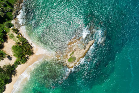 Aerial top view Drone camera top down of seashore rocks in Phuket ocean Sea waves on beautiful seascape aerial view drone sea surface ocean waves crashing against an empty stone rock cliff.の写真素材