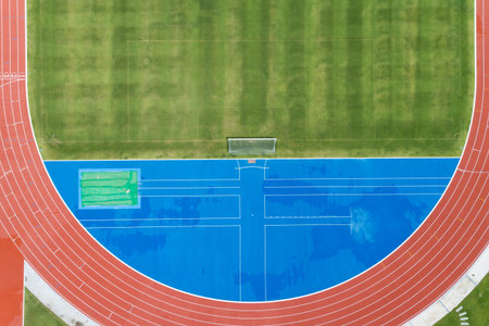 Aerial view of empty new soccer field from above with running tracks around it Amazing new small...