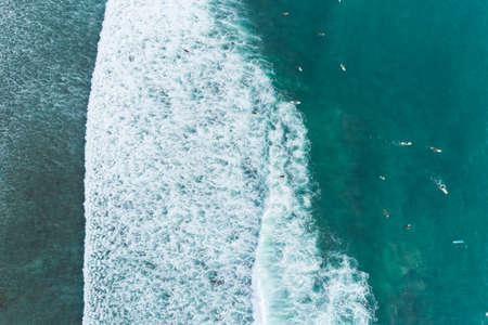Amazing aerial view Top down of waves break on tropical sea Surfers with surfing boards Aerial drone view of sea waves on the beautiful ocean at Phuket Thailand.の写真素材