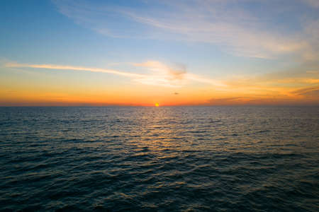 Aerial view Beautiful view sunset over sea surface beautiful wave Amazing light sunset or sunrise sky over sea beach with wave crashing on sandy shoreの写真素材