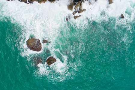 Aerial view of sea crashing waves White foaming waves on seashore rocks Top view fantastic Rocky coast Amazing nature backgroundの写真素材