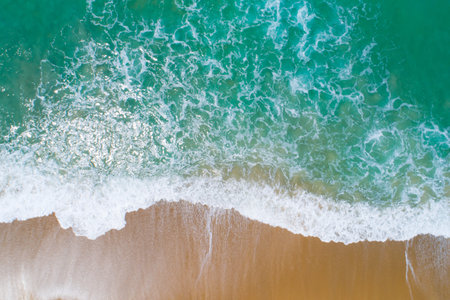 Aerial view sandy beach and waves crashing on sand. Beautiful tropical sea in the morning summer...