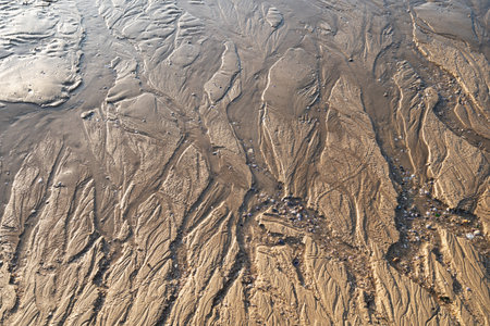 Patterns on sandy beach after low tide on the ocean.abstract sand nature background. Close up of...