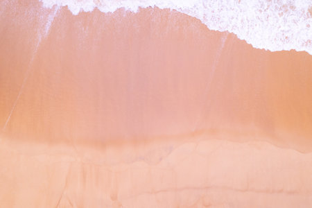 Beach Sand Sea Shore and waves white foamy summer sunny day background.Amazing beach top down view overhead seaside nature backgroundの写真素材