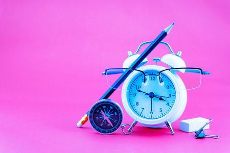 Concept Education or business Alarm clock and teacher glasses Business objects isolated on colorful...
