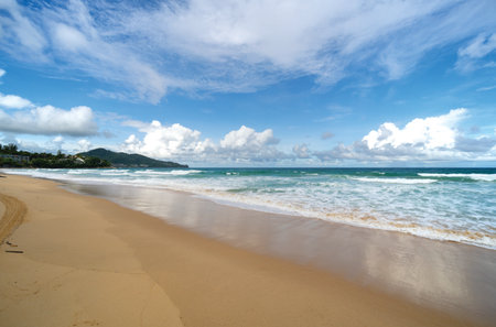 Beautiful sandy beach and sea waves crashing on sandy shore with clear blue sky background,Amazing beach blue sky sun daylight relaxation landscape view,Beach for Summer and travel backgroundの写真素材